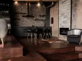Nowoczesna kuchnia z ceglaną ścianą i meblami w kolorze heban. Obok kominek i designerski fotel.