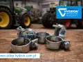 Metalowe opaski zaciskowe, czyli trytytki, na drewnianym blacie. W tle zielone traktory i logo Hydron.