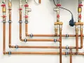 System hydrauliczny z miedzianymi rurami i zaworami. Różnica między złączkami PEX U czy TH jest kluczowa dla szczelności instalacji.