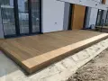 Nowy taras na słupach betonowych, wykonany z desek kompozytowych, stanowi idealne miejsce do wypoczynku.