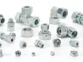 Różnorodne metalowe elementy hydrauliczne, w tym trójniki, kolanka i złączki, tworzą skomplikowany śrubunek.