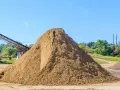 Ogromna hałda piasku na placu budowy. Zastanawiasz się, ile kosztuje tona piasku? Tu jest odpowiedź, choć cena może się różnić.