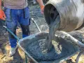 Robotnik wylewa beton B25 z betoniarki do taczki. Sprawdzamy beton b25 cena za m3.