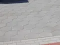 Szara, sześciokątna trelinka tworzy wzór na chodniku.