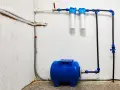 System hydrofornia z niebieskim zbiornikiem, dwoma filtrami wody i instalacją rurową.
