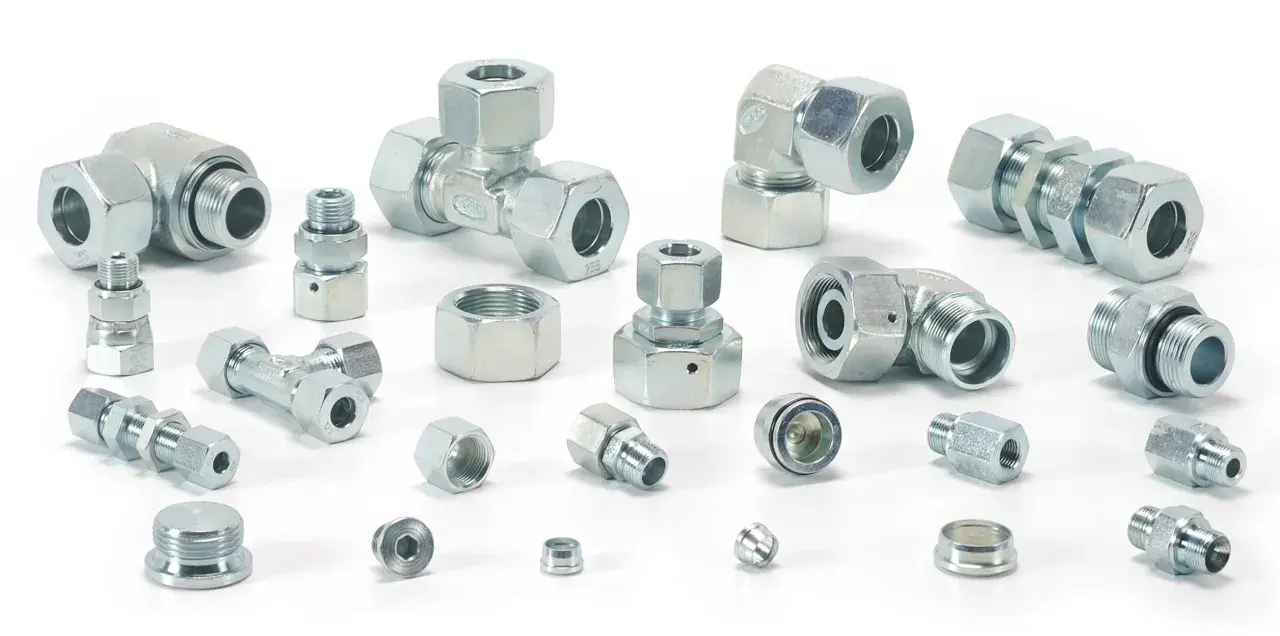 Różnorodne metalowe elementy hydrauliczne, w tym trójniki, kolanka i złączki, tworzą skomplikowany śrubunek.