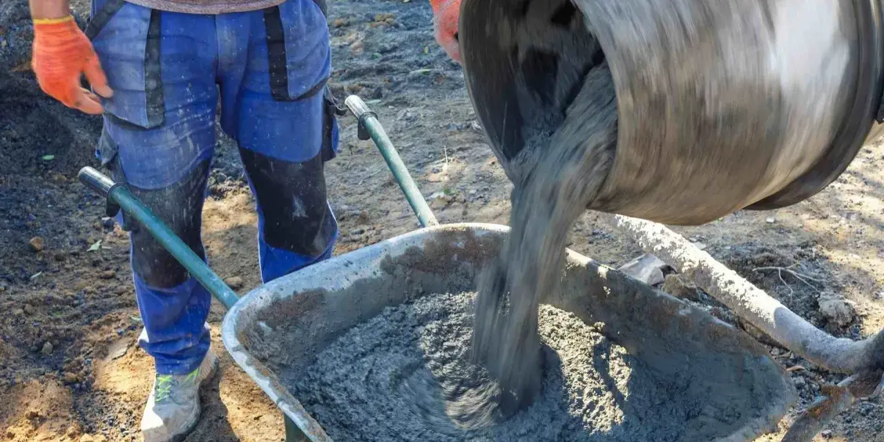 Robotnik wylewa beton B25 z betoniarki do taczki. Sprawdzamy beton b25 cena za m3.
