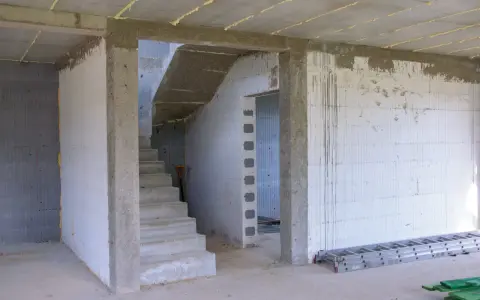 Wnętrze budowy z betonowymi schodami i otwartym przejściem. Idealny jaki otwór pod drzwi 80, by pomieścić standardowe drzwi.