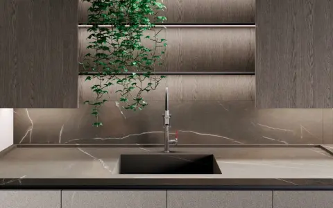 Nowoczesna kuchnia z blatem i płytą backsplash z kamienia, przypominającego marmur. Wisząca zieleń dodaje życia.