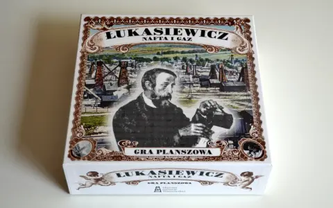 Pudełko gry planszowej "Łukasiewicz: Nafta i Gaz" z Ignacym Łukasiewiczem na tle szybów naftowych.