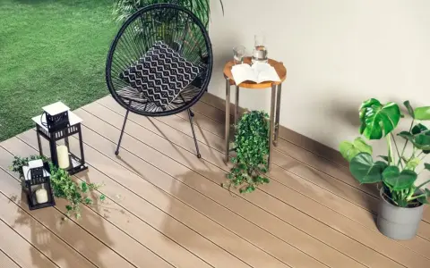 Drewno kompozytowe to świetny pomysł, czym wyłożyć balkon. Wygodne krzesło, stolik i rośliny tworzą przytulną przestrzeń.
