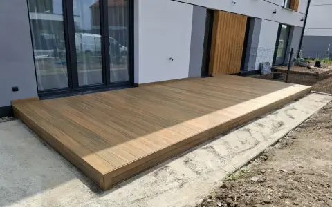 Nowy taras na słupach betonowych, wykonany z desek kompozytowych, stanowi idealne miejsce do wypoczynku.
