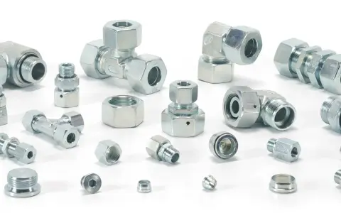 Różnorodne metalowe elementy hydrauliczne, w tym trójniki, kolanka i złączki, tworzą skomplikowany śrubunek.