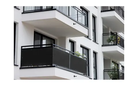 Ciemna osłona na balustradę balkonu, idealna, by zapewnić prywatność i ochronę przed wiatrem.