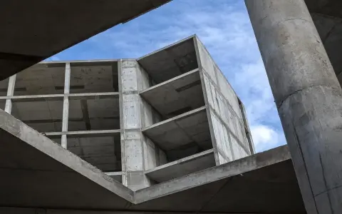 Szkielet budynku z betonu, widok od dołu na niebo. Konstrukcja z betonu, jakby z **styrobetonu**, czeka na wykończenie.