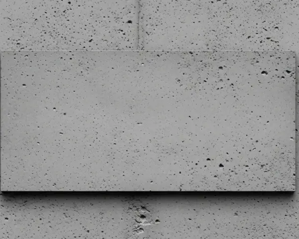 Szara, prostokątna płyta z widocznym efektem surowego betonu na ścianie. Tekstura z licznymi porami i nierównościami.