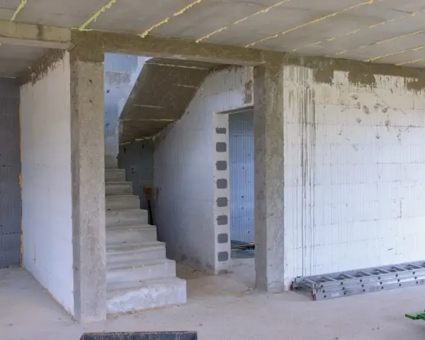 Wnętrze budowy z betonowymi schodami i otwartym przejściem. Idealny jaki otwór pod drzwi 80, by pomieścić standardowe drzwi.
