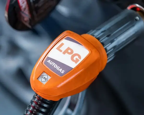 Pomarańczowa końcówka dystrybutora LPG z napisem "AUTOGAS". Rozważasz koszt instalacji gazowej?