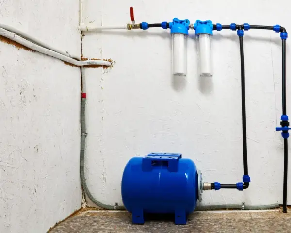 System hydrofornia z niebieskim zbiornikiem, dwoma filtrami wody i instalacją rurową.