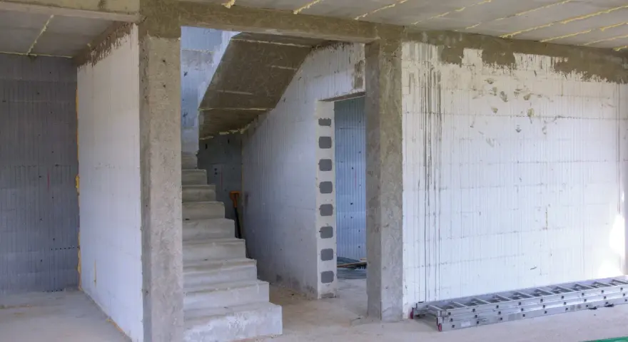 Wnętrze budowy z betonowymi schodami i otwartym przejściem. Idealny jaki otwór pod drzwi 80, by pomieścić standardowe drzwi.