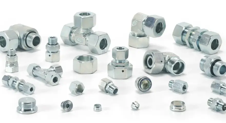 Różnorodne metalowe elementy hydrauliczne, w tym trójniki, kolanka i złączki, tworzą skomplikowany śrubunek.
