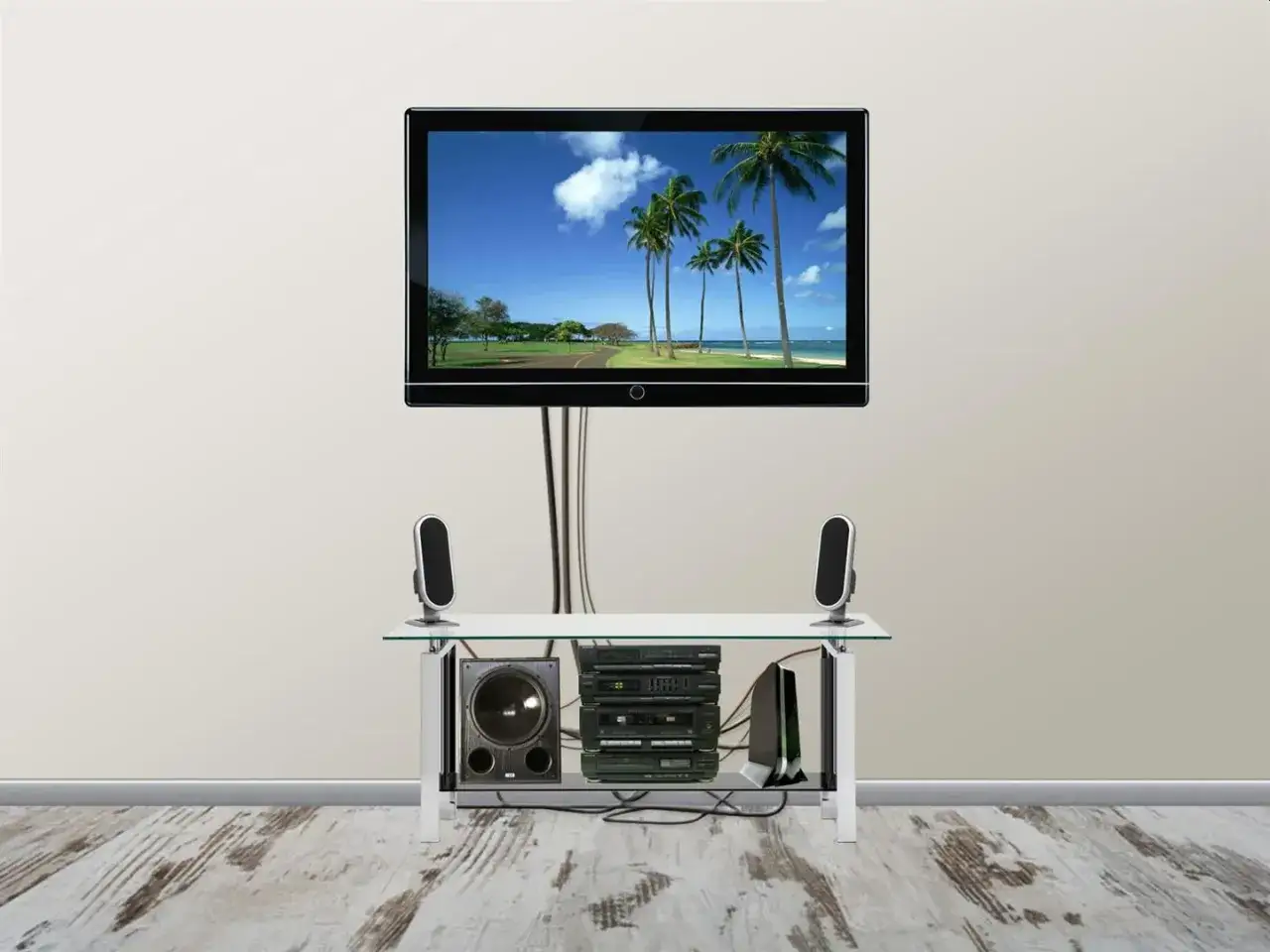 Nowoczesny telewizor z palmami na ekranie, pod którym stoi szklana półka z głośnikami i sprzętem audio. Wszystkie kable ukryte w rozwiązaniu kanał telewizyjny podtynkowy.