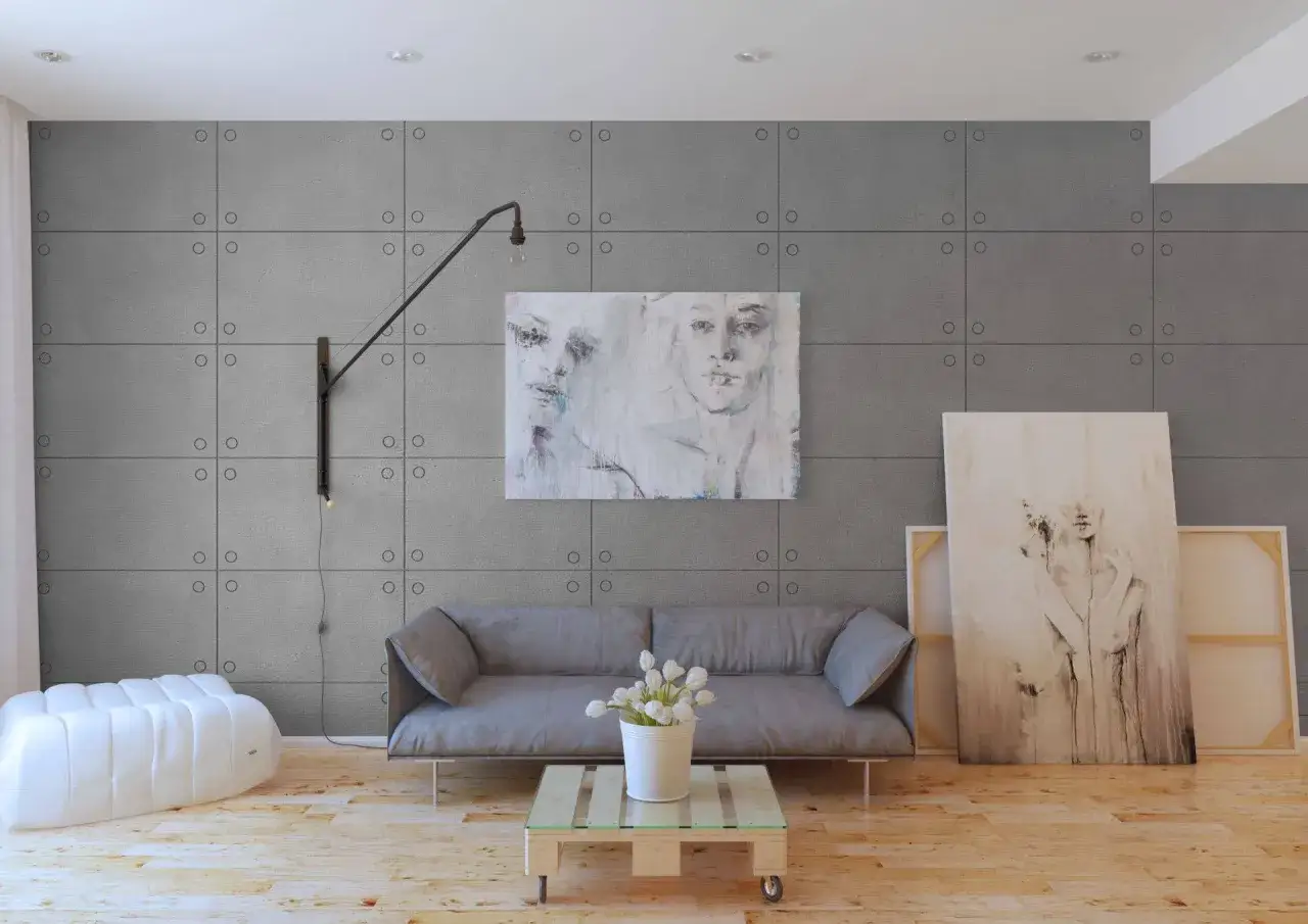Nowoczesny salon z szarą kanapą, sztuką na ścianie i panelem z efektem surowego betonu.