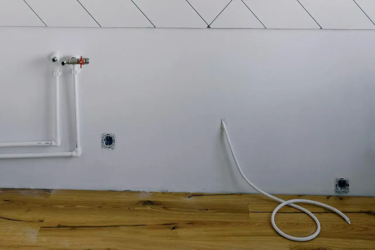Instalacja gazowa w trakcie prac. Widoczne rury, gniazdka i biały kabel. Szacowany koszt instalacji gazowej może się różnić.